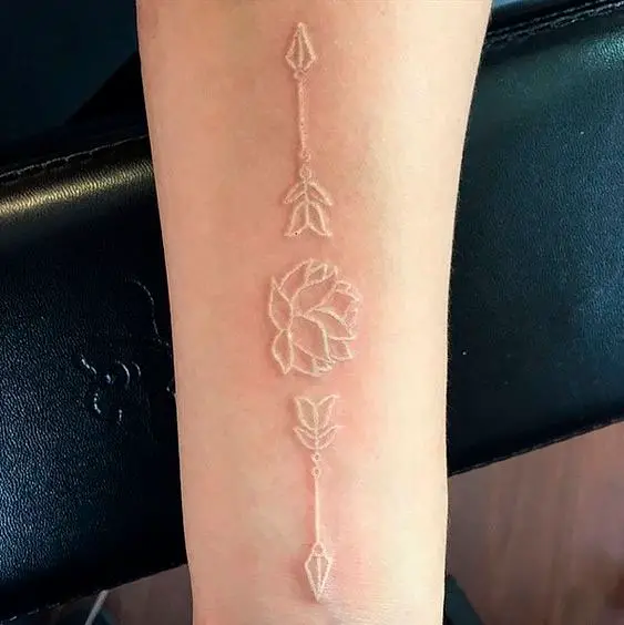 Tatuagens de flor de lótus e setas brancas