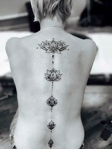 Flores de lótus tatuada na coluna