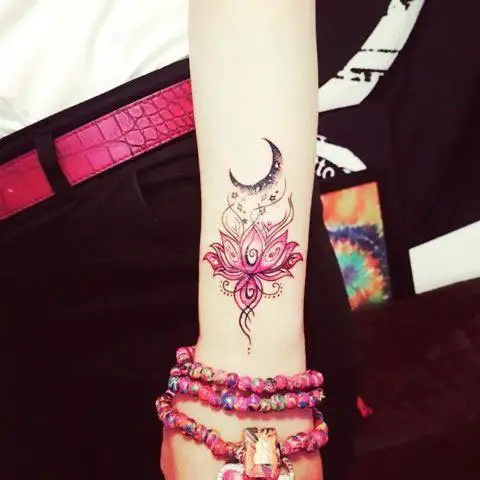 Flor de lótus e lua tatuada no antebraço