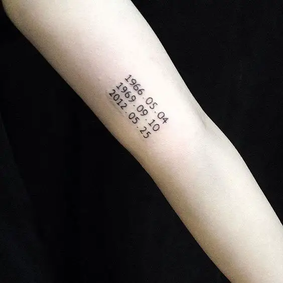 Tatuagem no braço com datas de nascimento