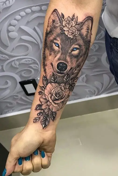 Tatuagem feminina no braço de loba e rosas