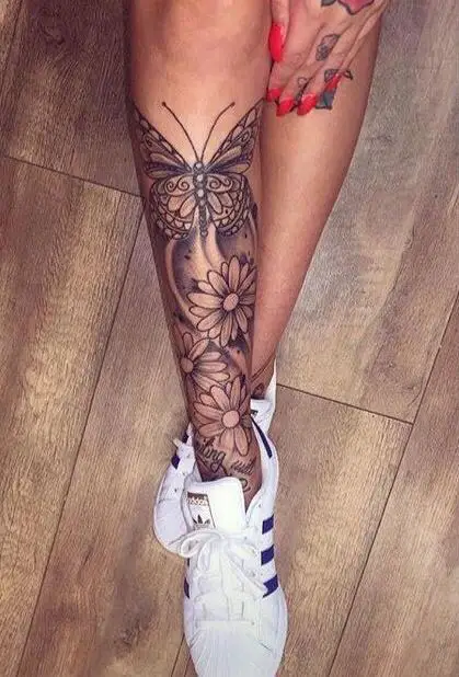 Tatuagens na perna feminina de borboleta e flores