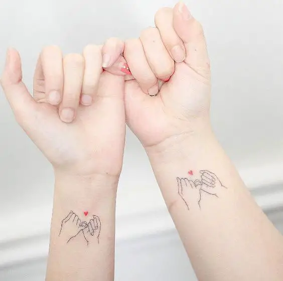 Tatuagens mãe e filha de mãos dadas
