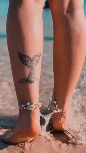 Tatuagem feminina de sereia na perna
