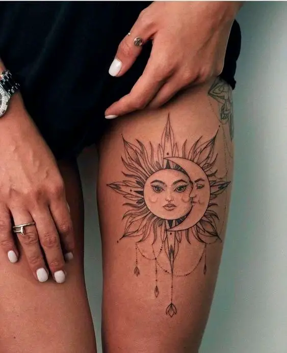 Tatuagem feminina na perna de sol e lua