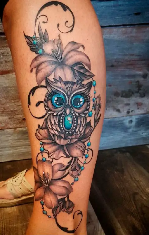 Tatuagem feminina na perna de coruja