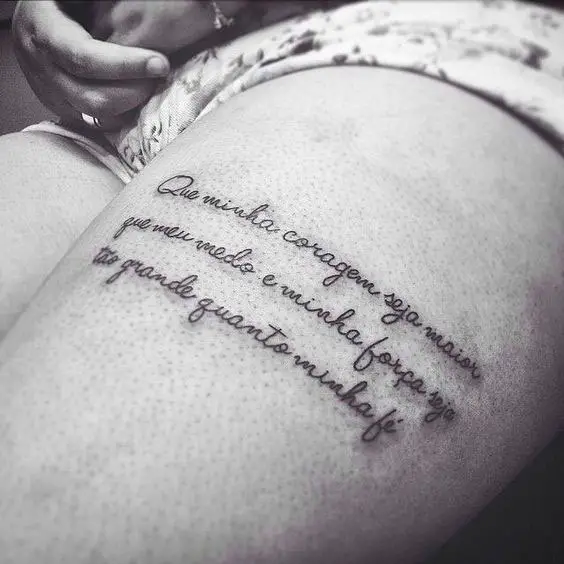 Tatuagem na perna feminina na coxa com frase