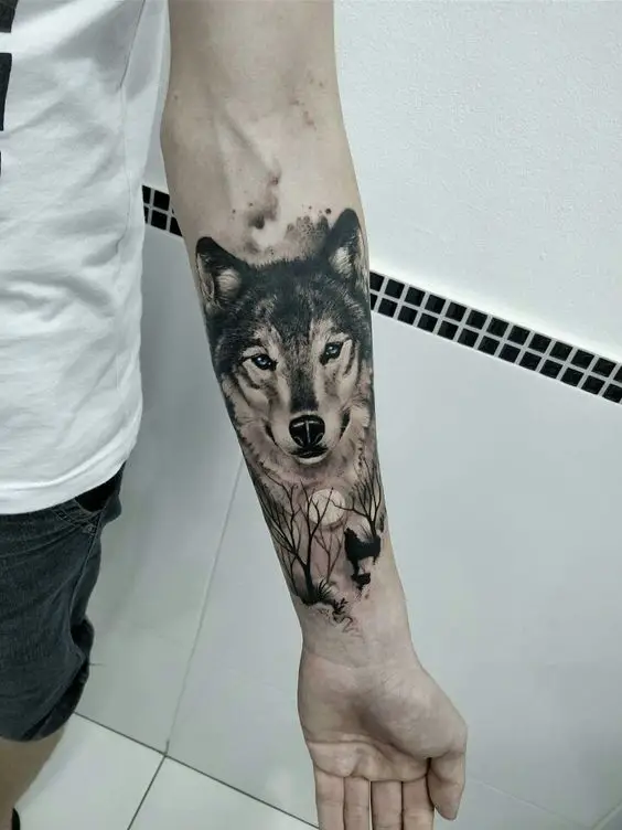 Tatuagem com a face de lobo no antebraço com Lua e lobo uivando