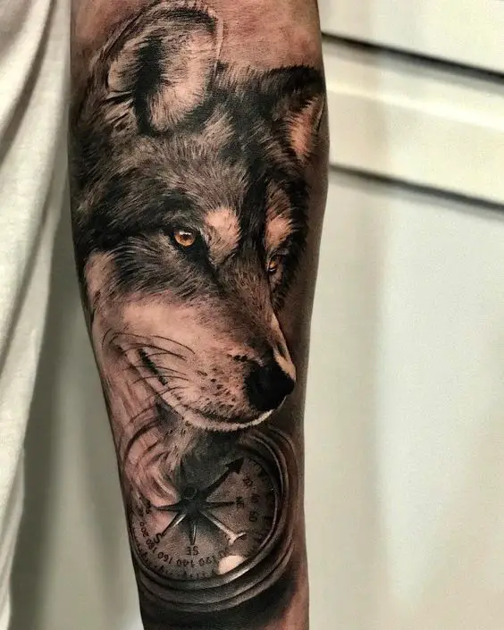 Tatuagem de Lobo no antebraço com bússola