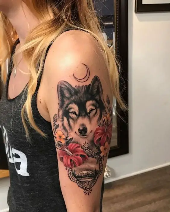Tatuagem feminina de Lobo e lua no braço