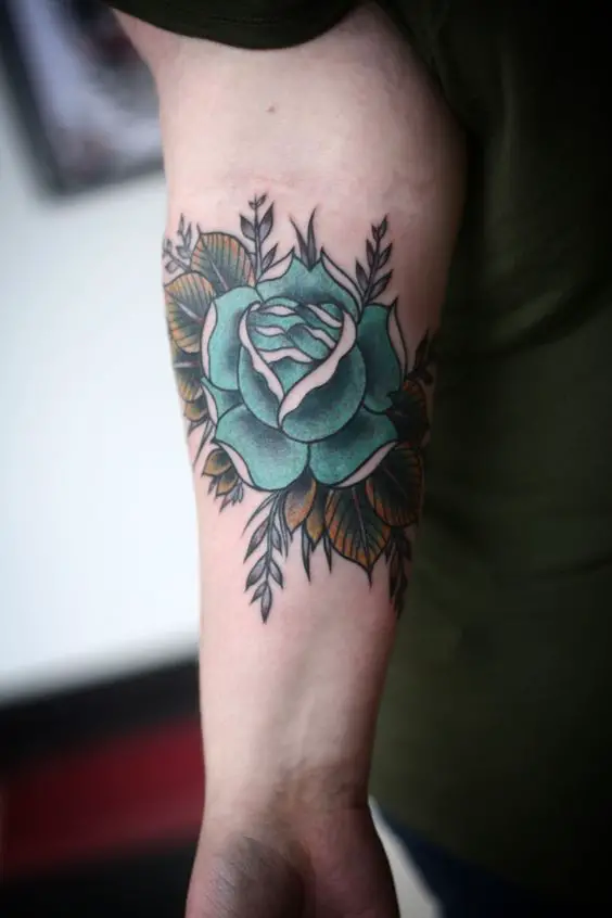 Tatuagem de Rosa Azul com folhas no braço