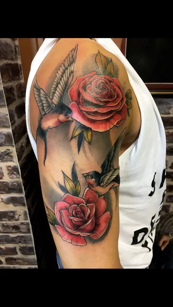 Tatuagem com rosas e passarinhos no braço e ombro