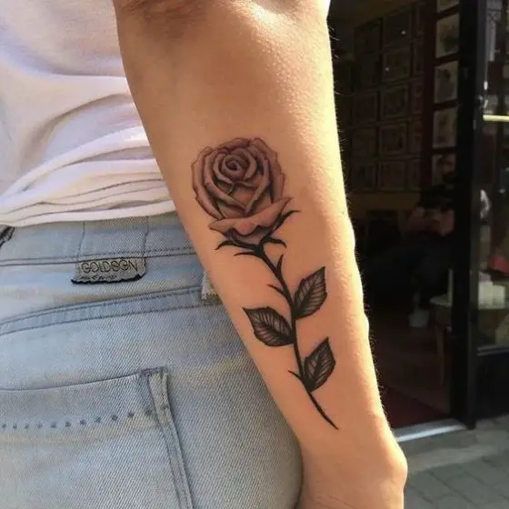 Tatuagem de Rosa com folhas e espinhos no antebraço