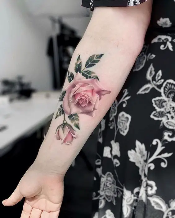 Rosa colorida e folhas no antebraço