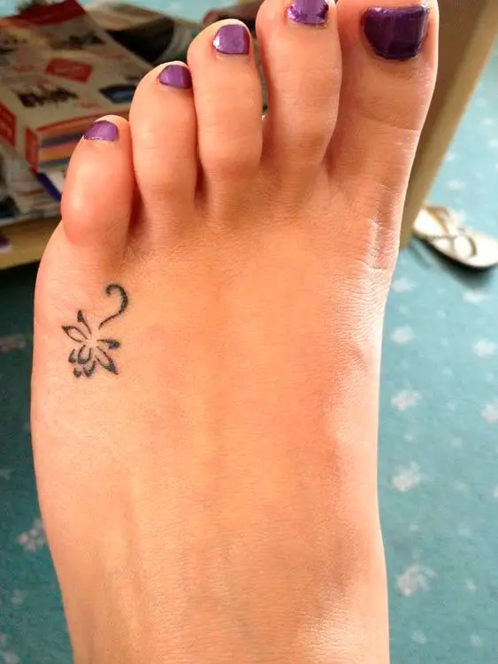 Tatuagem de flor de lótus delicada no pé para mulher