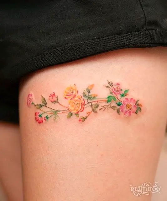 Tatuagem na coxa delicada com flores