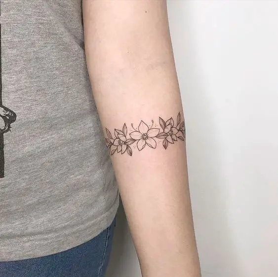 Tatuagem para mulher no braço com flores